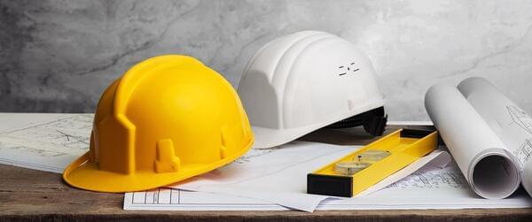 Construction helmet, roll of blueprints, magnetic box level